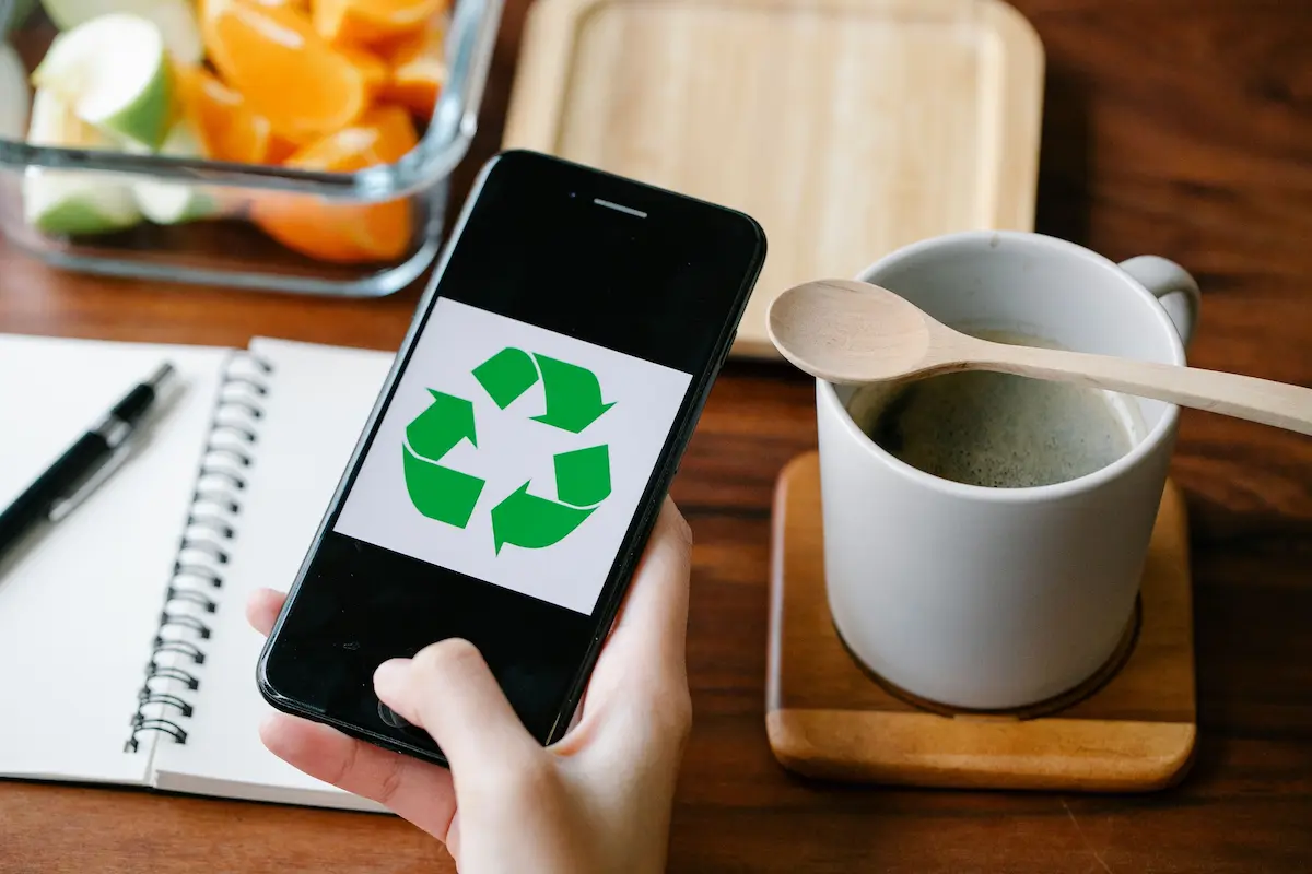 smartphone avec logo recyclage, mug de café et carnet de notes
