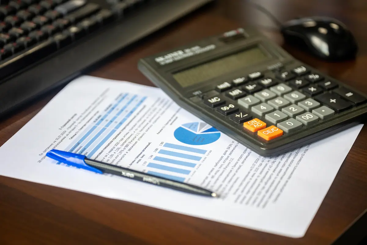 calculatrice sur un bureau avec une feulle représentant des graphiques et diagrammes
